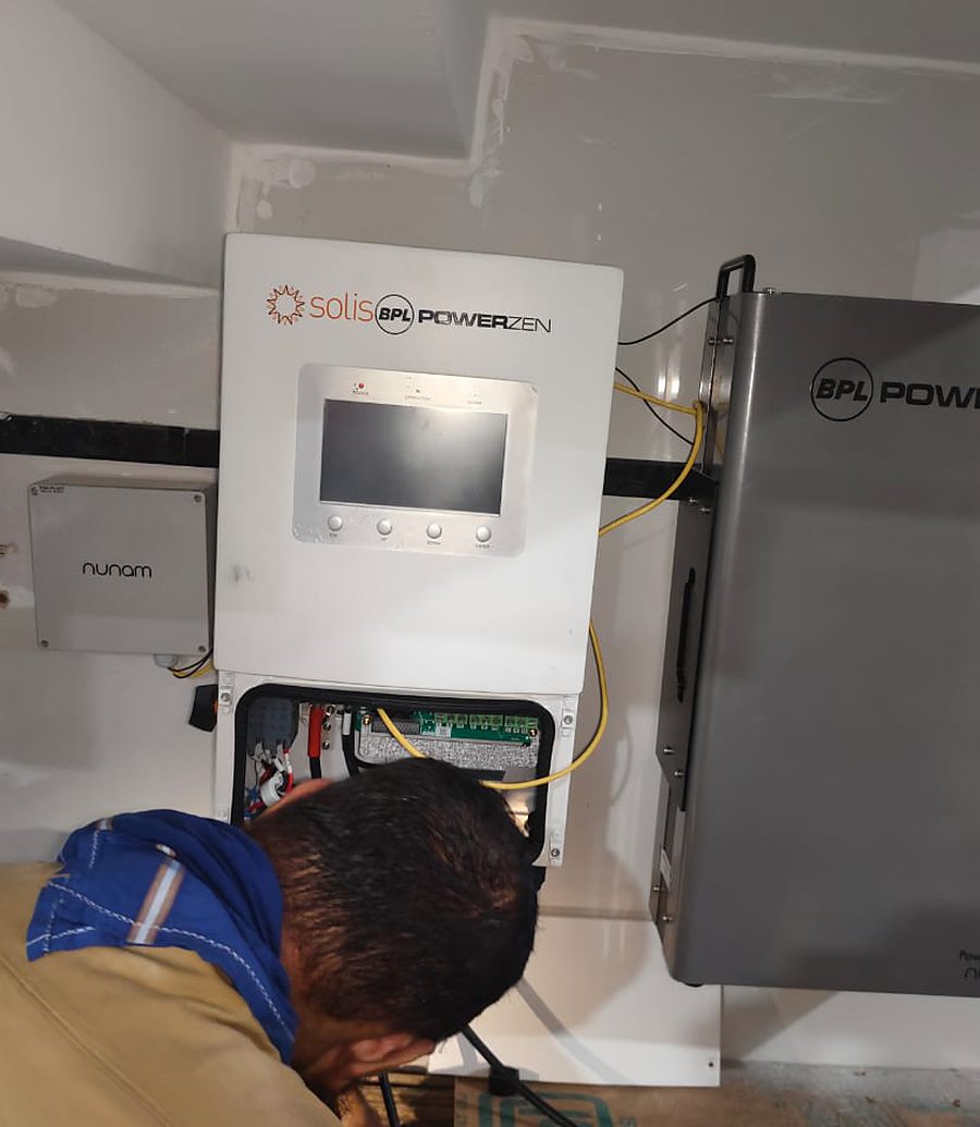 Technician commissioning a wall-mounted inverter and battery system